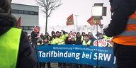 Die Streikenden fordern kämpferisch Tarifbindung der SWR, acht Prozent mehr Lohn und halten Fahnen der IG Metall hoch
