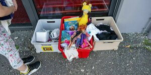 Eine Spendenkiste mit Spielsachen, Kleidung und Elektronik vor der Tür des Familiencafés im SOS-Kinderdorf in München-Riem.