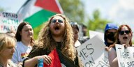 Menschen protestieren mit Schildern und Palästina Flaggen auf dem Campus